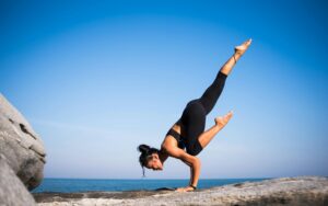 Woman practicing yoga outdoors on a sunny day, symbolizing mindfulness, summer wellness, and the YogaLean lifestyle.